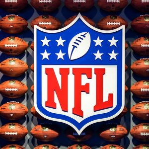 Image of the NFL logo with footballs surrounding it.