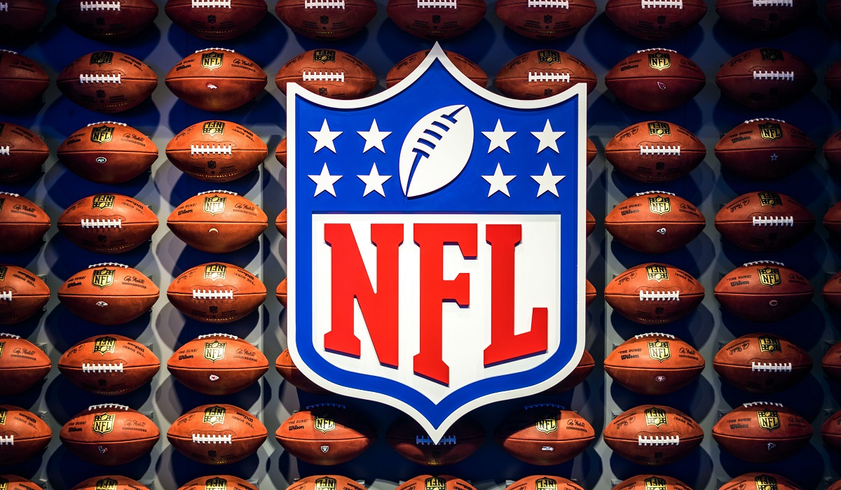 Image of the NFL logo with footballs surrounding it.