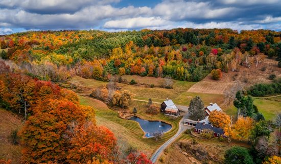 A barn nestled in a valley during fall.