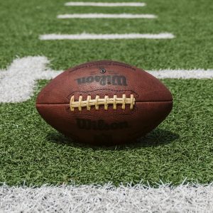 Image of a football on green grass.