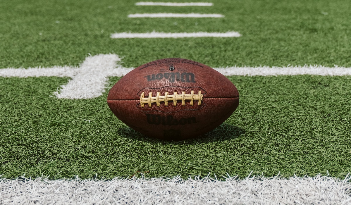 Image of a football on green grass.