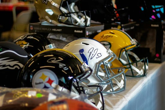 American football helmets sitting in a row.